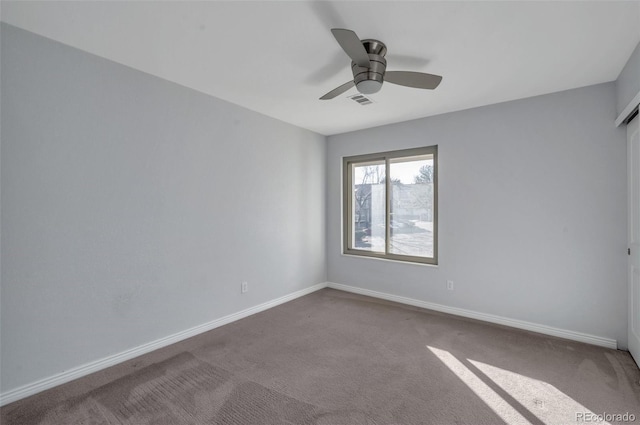 spare room featuring ceiling fan and carpet flooring