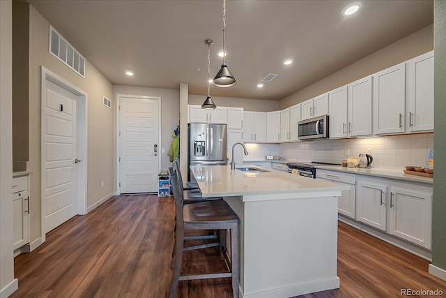 kitchen featuring sink, dark wood-type flooring, white cabinetry, a kitchen island with sink, and stainless steel appliances