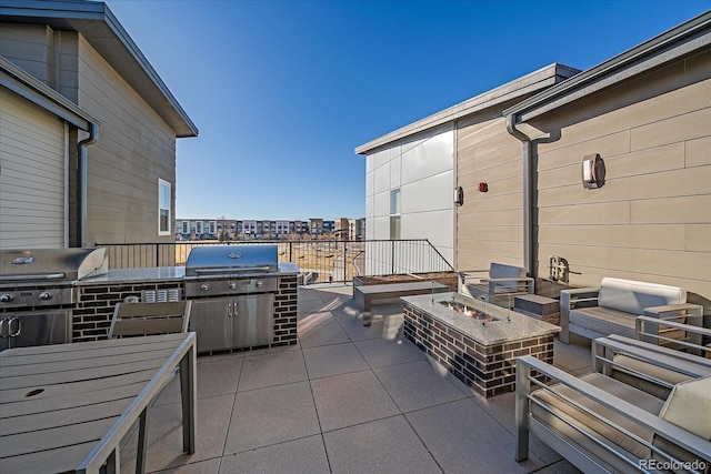 view of patio with a grill, area for grilling, and a fire pit