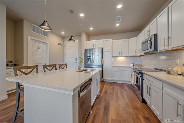 420 E Fremont Pl Unit 203, Centennial, CO 80122 - kitchen with stainless steel appliances, a kitchen bar, backsplash, dark wood-type flooring, and recessed lighting