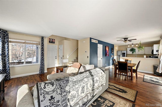 bedroom with ceiling fan, stainless steel fridge, dark hardwood / wood-style floors, and two closets