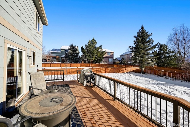 snow covered deck with a grill