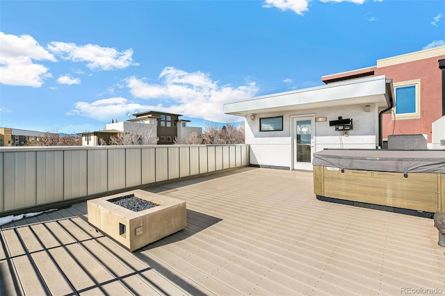 deck with a hot tub and a fire pit