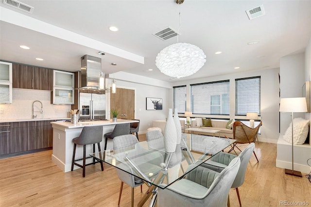 dining area with sink and light hardwood / wood-style floors