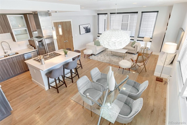 living room featuring sink and light hardwood / wood-style flooring