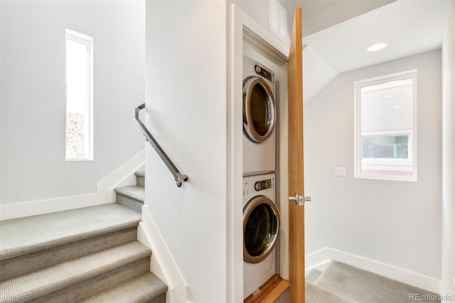 laundry room with stacked washer and dryer, a healthy amount of sunlight, and carpet