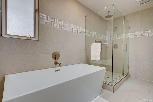 3434 S Race St, Englewood, CO 80113 - bathroom featuring tile walls, a stall shower, a soaking tub, and tile patterned flooring