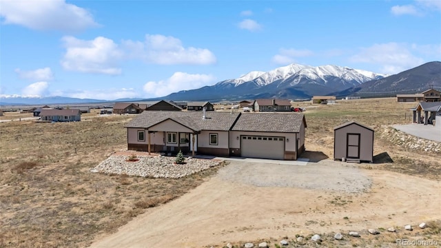 16651 Holly Ct, Buena Vista, CO 81211 - view of front of house featuring a shed, a mountain view, an attached garage, and driveway