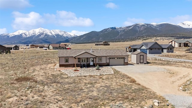 16651 Holly Ct, Buena Vista, CO 81211 - view of front facade with a garage, a storage unit, a mountain view, and dirt driveway