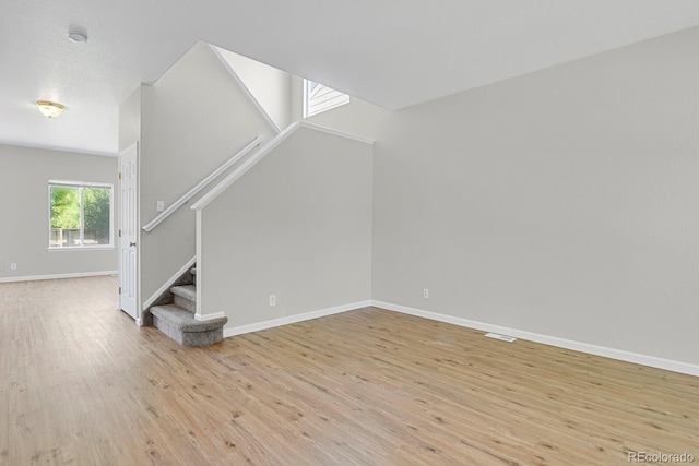 9690 Lansing Cir, Commerce City, CO 80022 - unfurnished living room with light wood finished floors, stairway, and baseboards