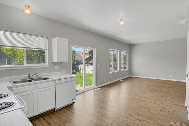 9690 Lansing Cir, Commerce City, CO 80022 - kitchen featuring white appliances, a sink, light wood-style flooring, open floor plan, and white cabinets