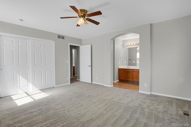 9690 Lansing Cir, Commerce City, CO 80022 - unfurnished bedroom featuring light carpet, arched walkways, baseboards, and a closet
