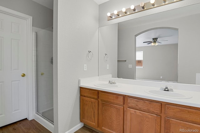 9690 Lansing Cir, Commerce City, CO 80022 - bathroom with a ceiling fan, double vanity, wood finished floors, and a tile shower