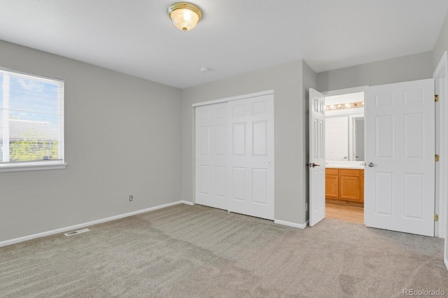 9690 Lansing Cir, Commerce City, CO 80022 - unfurnished bedroom with light colored carpet, a closet, baseboards, and ensuite bathroom