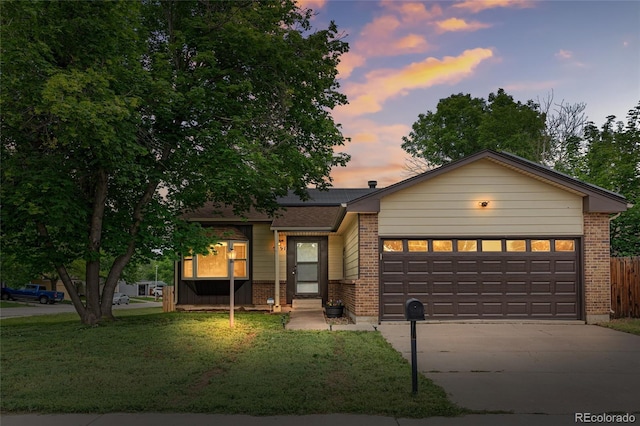 5991 W 68th Ave, Arvada, CO 80003 - view of front of home featuring brick siding, concrete driveway, and a garage