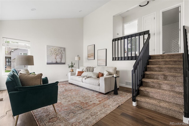 5991 W 68th Ave, Arvada, CO 80003 - living room with healthy amount of natural light, wood finished floors, baseboards, stairs, and high vaulted ceiling