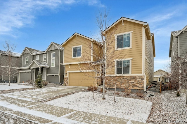 view of front of home featuring a garage, stone siding, and driveway