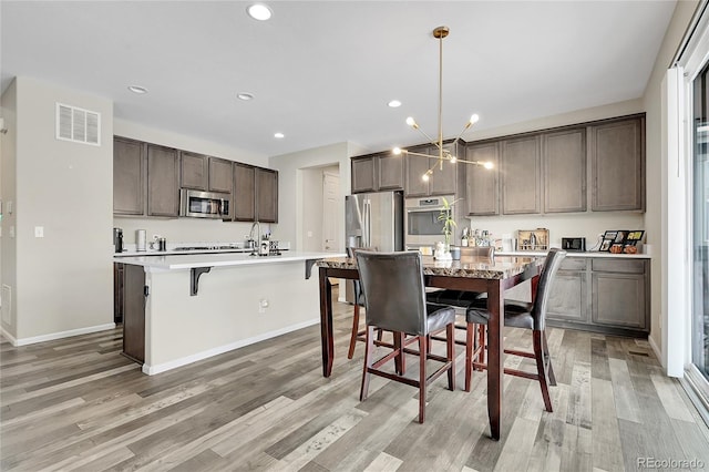 dining room featuring a notable chandelier, recessed lighting, visible vents, baseboards, and light wood finished floors