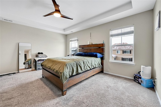 bedroom featuring baseboards, visible vents, a raised ceiling, a ceiling fan, and carpet floors