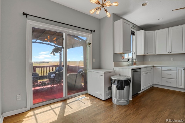 kitchen with stainless steel dishwasher, white cabinetry, and hardwood / wood-style floors