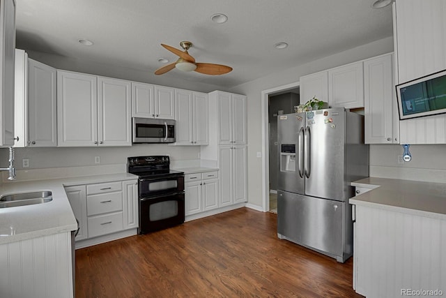 kitchen featuring ceiling fan, sink, stainless steel appliances, dark hardwood / wood-style floors, and white cabinets