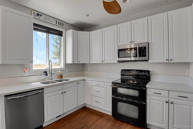 kitchen with appliances with stainless steel finishes, dark hardwood / wood-style flooring, ceiling fan, sink, and white cabinets