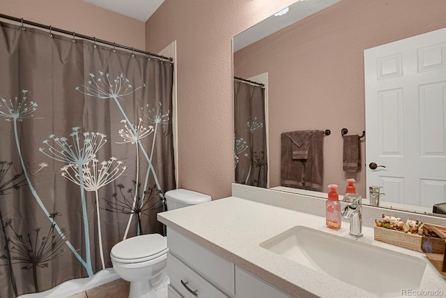 bathroom featuring tile patterned floors, vanity, and toilet