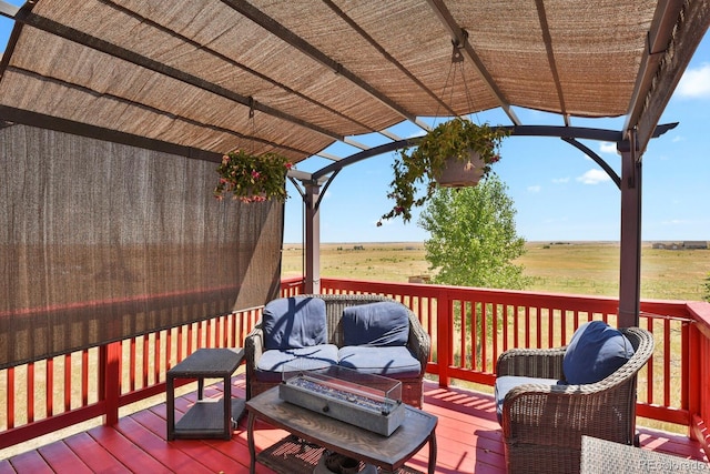 deck featuring a pergola, a rural view, and a fire pit