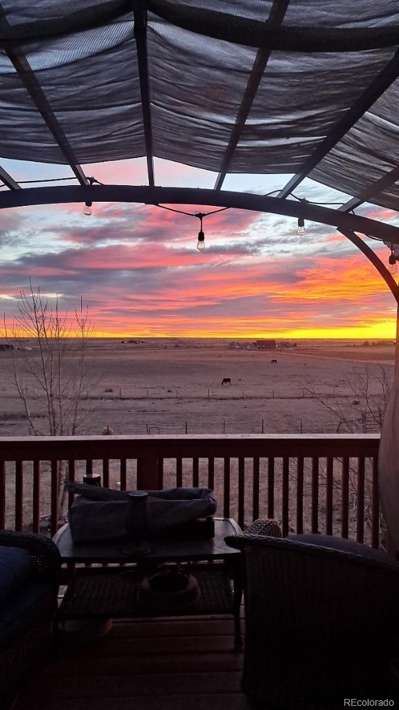 deck at dusk featuring a water view