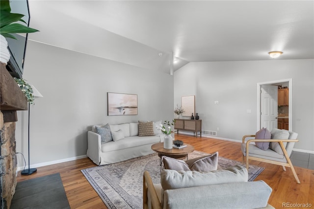 living room featuring hardwood / wood-style flooring and vaulted ceiling