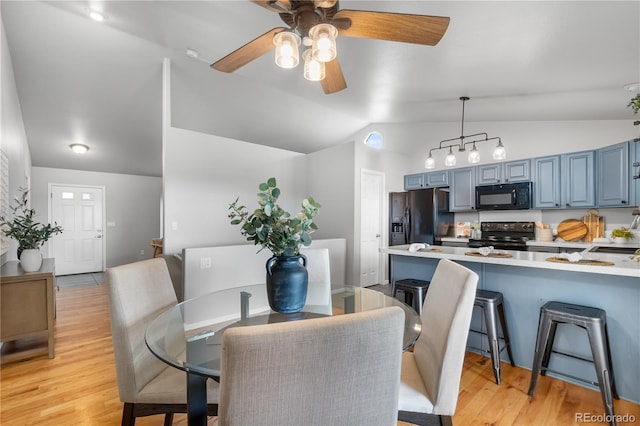 dining area featuring vaulted ceiling, ceiling fan, and light wood-type flooring