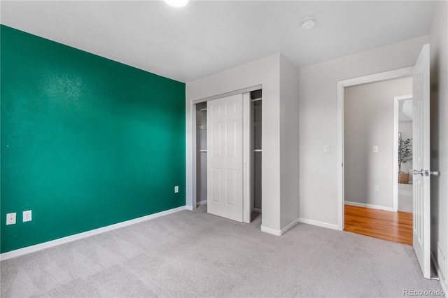 unfurnished bedroom with light carpet and a closet