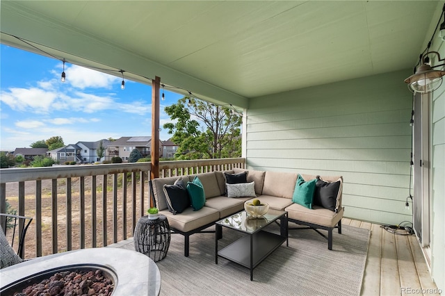 wooden deck featuring an outdoor living space with a fire pit