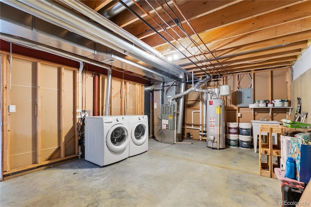 basement featuring washer and dryer, electric panel, water heater, and heating unit