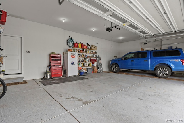 garage with white fridge and a garage door opener