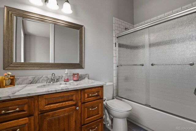 full bathroom featuring vanity, toilet, and enclosed tub / shower combo