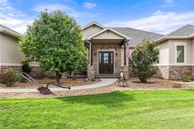 view of exterior entry with a yard