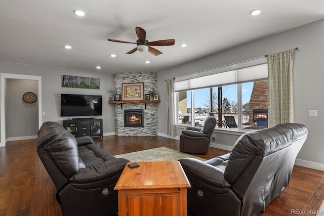 living room with ceiling fan, a fireplace, and dark wood-type flooring