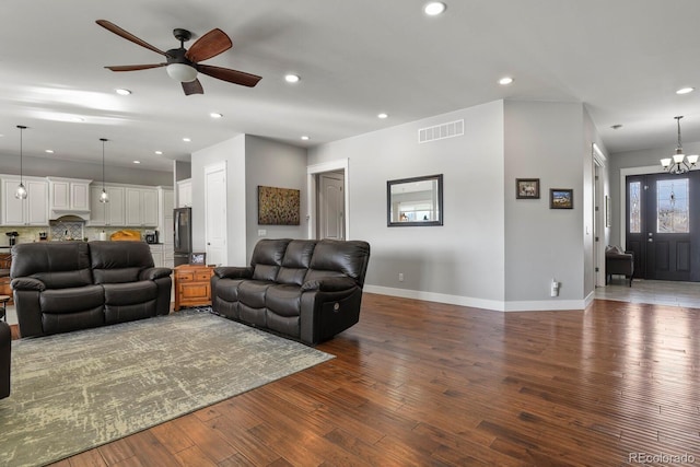 living room with hardwood / wood-style flooring and ceiling fan with notable chandelier