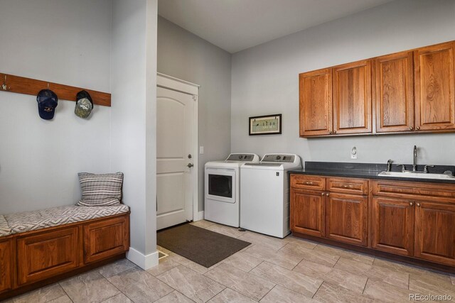 laundry room with washing machine and dryer, sink, and cabinets