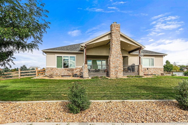 rear view of property featuring a porch and a yard