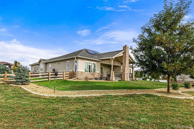 17155 Primrose Ln, Mead, CO 80542 - view of front of home with stucco siding, roof mounted solar panels, a chimney, and stone siding