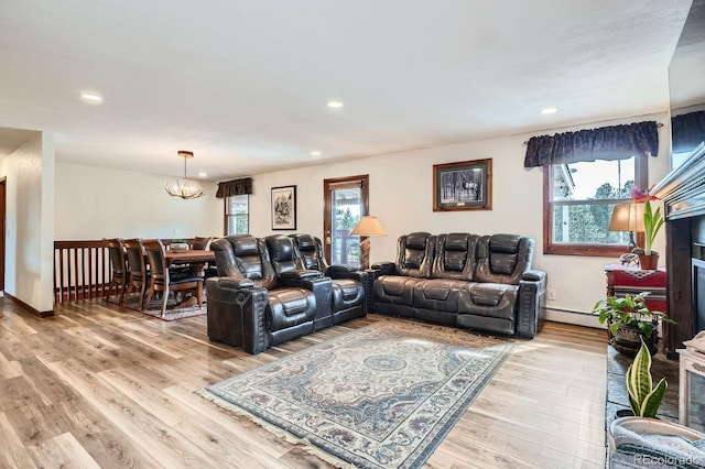 34886 Mohawk Trl, Pine, CO 80470 - living room with light wood finished floors, recessed lighting, a chandelier, a baseboard radiator, and a fireplace