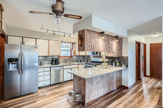34886 Mohawk Trl, Pine, CO 80470 - kitchen with stainless steel appliances, a sink, a peninsula, and light wood finished floors