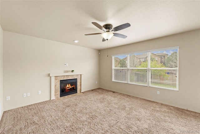 unfurnished living room with a fireplace, carpet flooring, a ceiling fan, and baseboards