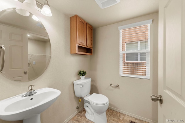 bathroom with a sink, baseboards, and toilet