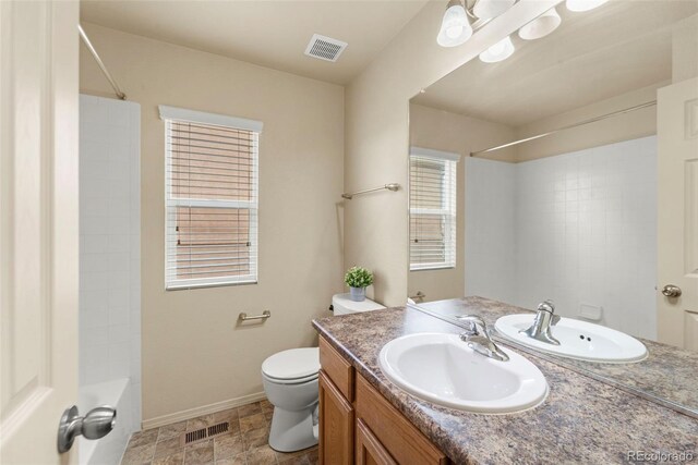 bathroom with baseboards, toilet, vanity, and  shower combination