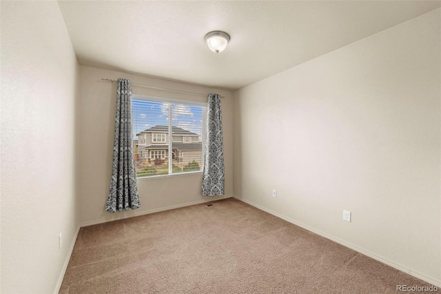 unfurnished room with light carpet and baseboards