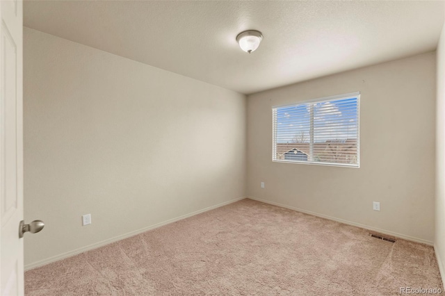 empty room featuring carpet and baseboards