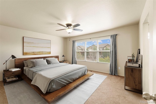 bedroom with light carpet, baseboards, and a ceiling fan